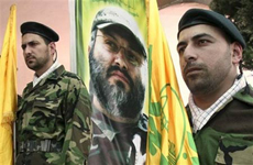 Các thành viên Hezbollah đứng gác trước một bức chân dung vị chỉ huy bị ám Imad Mughniyeh tại làng Tair Dibba, Lebanon hôm 23/3
